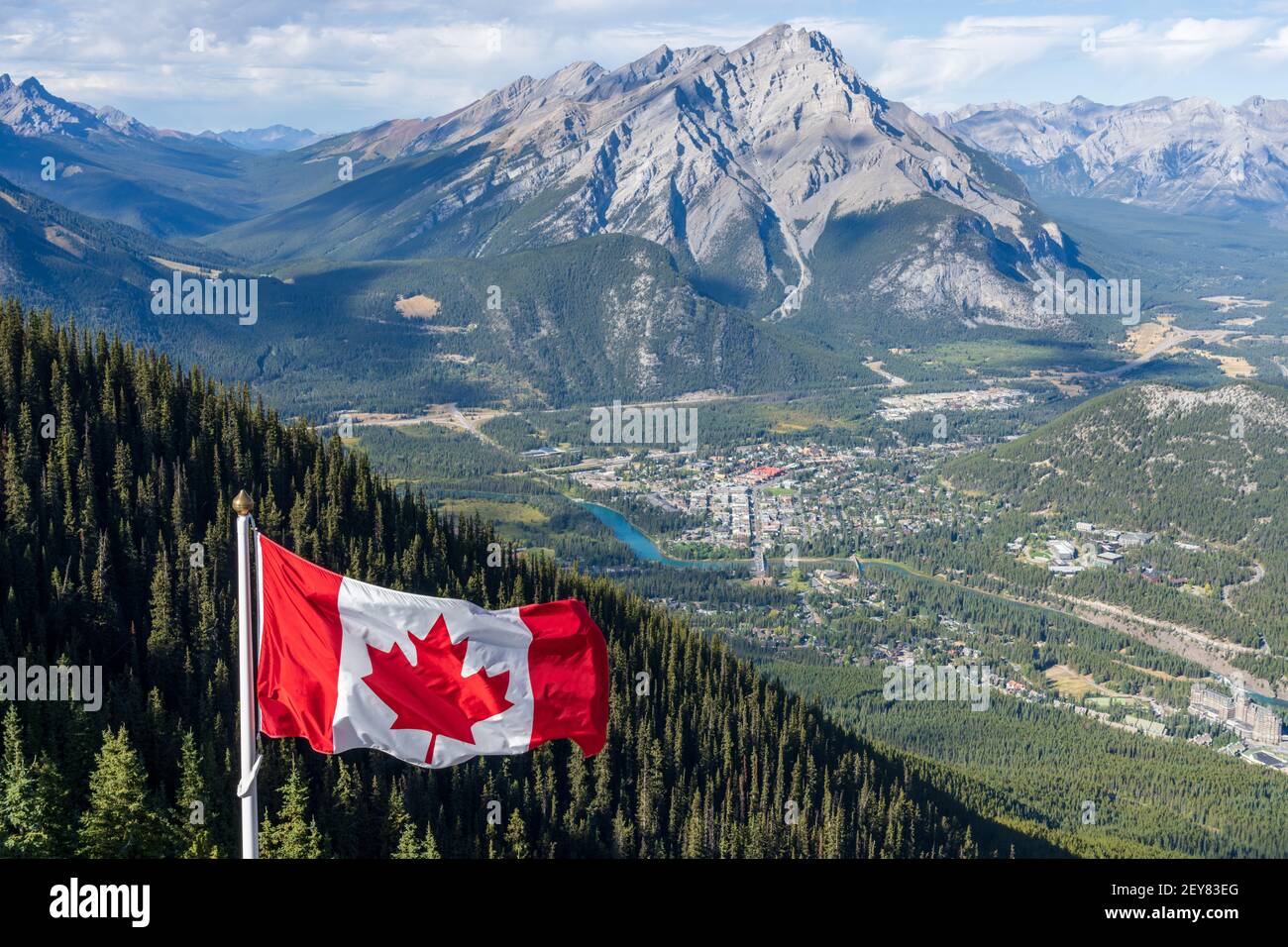 Nationale Flagge Kanadas mit der Stadt Banff im Hintergrund. Cascade Mountain und die umliegenden kanadischen Rocky Mountains im Sommer. Banff National Park Stockfoto
