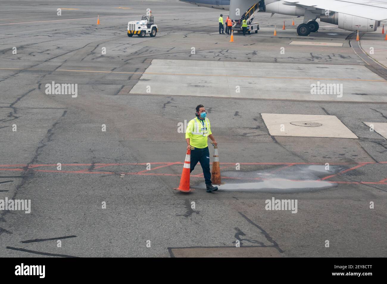Bogota, Kolumbien - Februar 25 2021: Latein Mann trägt Maske, Gelbes Hemd läuft die Runway mit einem Orange Kegel Stockfoto