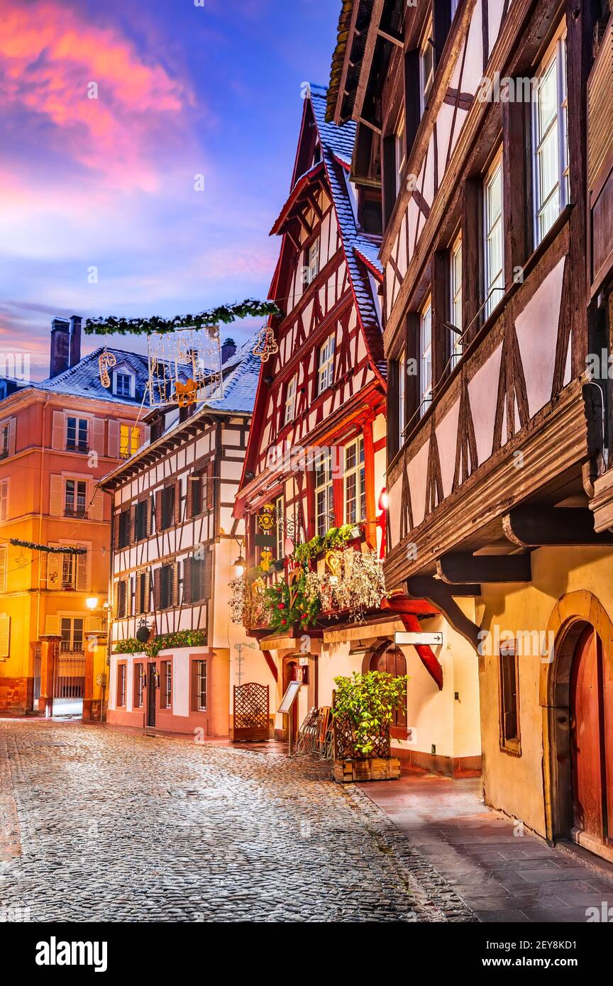 Straßburg, Frankreich. Traditionelle elsässische Fachwerkhäuser in Petite France während der Dämmerung zur Weihnachtszeit dekoriert. Stockfoto