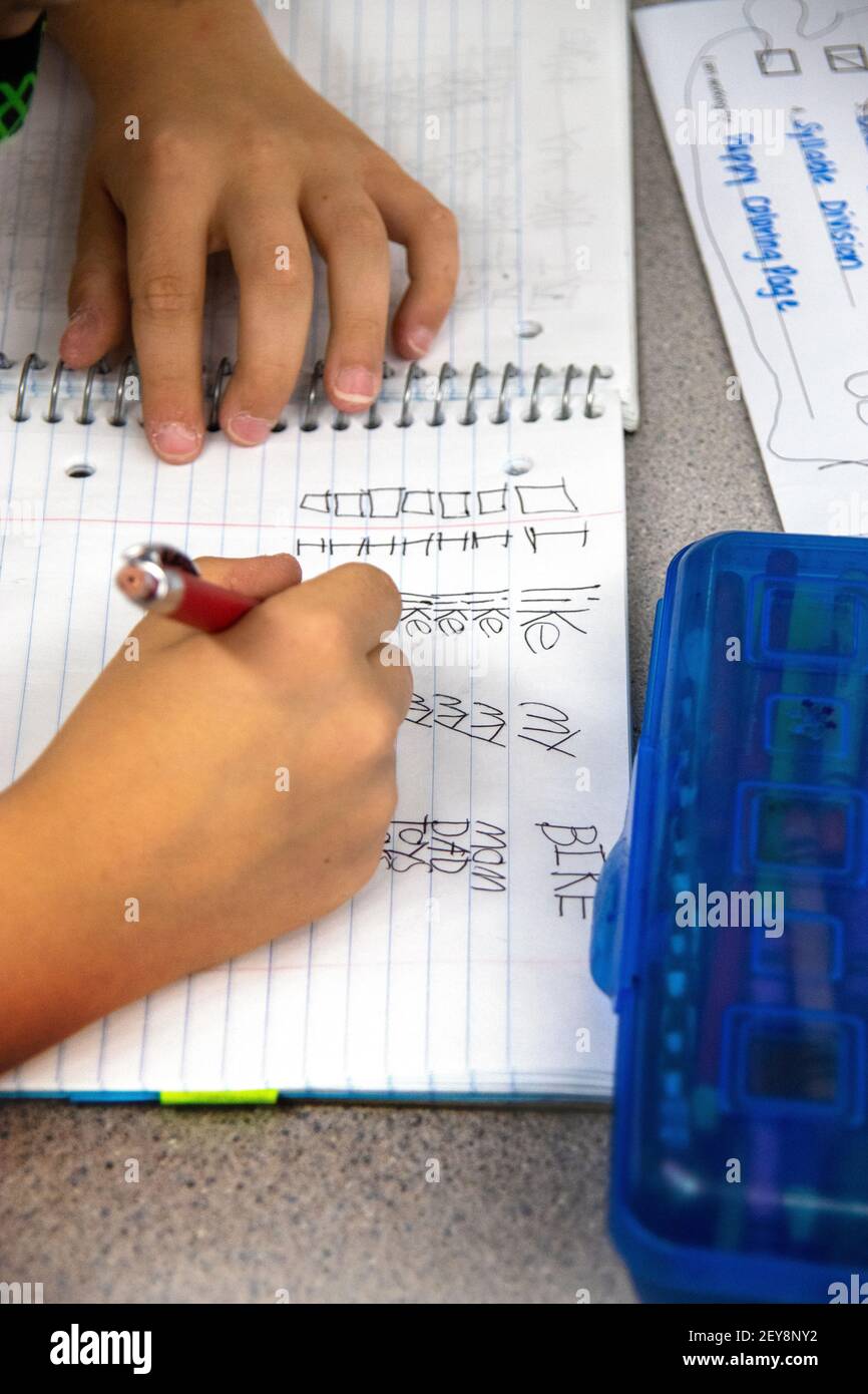 Ein Schüler der dritten Klasse in Kalifornien schreibt während eines Sprachkunstunterrichts Sätze mit verschiedenen Fächern. Stockfoto