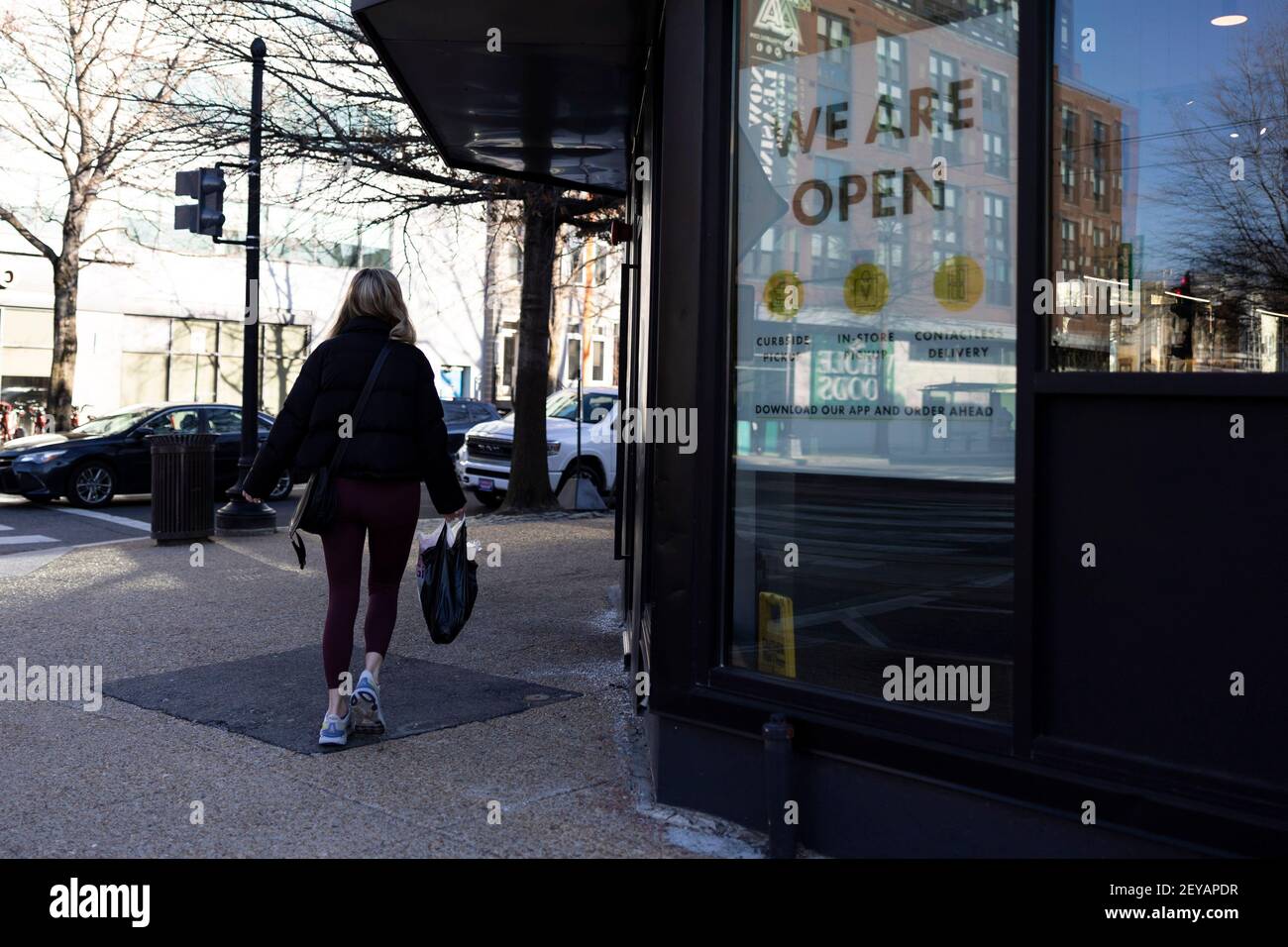 (210306) -- WASHINGTON, 6. März 2021 (Xinhua) -- EINE Frau geht an einem Laden vorbei, in dem ein Schild "Wir sind offen" steht, in Washington, DC, USA, 5. März 2021. US-Arbeitgeber hinzugefügt 379.000 Arbeitsplätze im Februar, mit der Arbeitslosenquote wenig verändert bei 6,2 Prozent, berichtete das Arbeitsministerium am Freitag. Im Februar traten die meisten Arbeitsgewinne in der Freizeit und im Gastgewerbe auf, mit kleineren Gewinnen in der temporären Hilfe, im Gesundheitswesen und in der Sozialhilfe, im Einzelhandel und in der Fertigung, laut dem monatlichen Bericht, der vom Büro für Arbeitsstatistik der Abteilung veröffentlicht wurde. (Foto von Ting Shen/ Stockfoto
