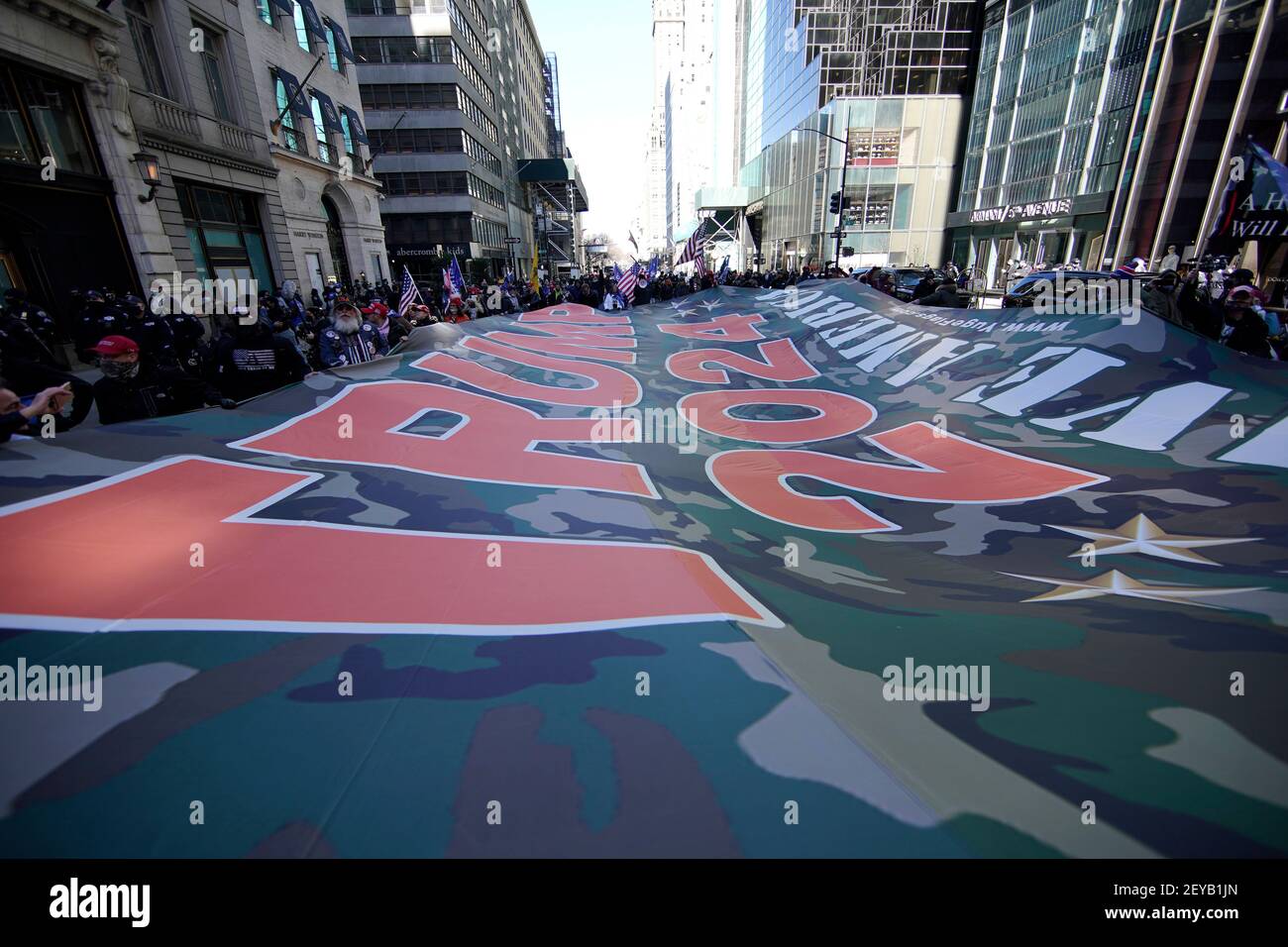 New York City, Usa. März 2021, 05th. Trump-Anhänger tragen nach einer Versammlung vor dem Trump Tower auf der Fifth Avenue eine riesige Trump-2024-Flagge in Richtung Times Square. Kredit: SOPA Images Limited/Alamy Live Nachrichten Stockfoto