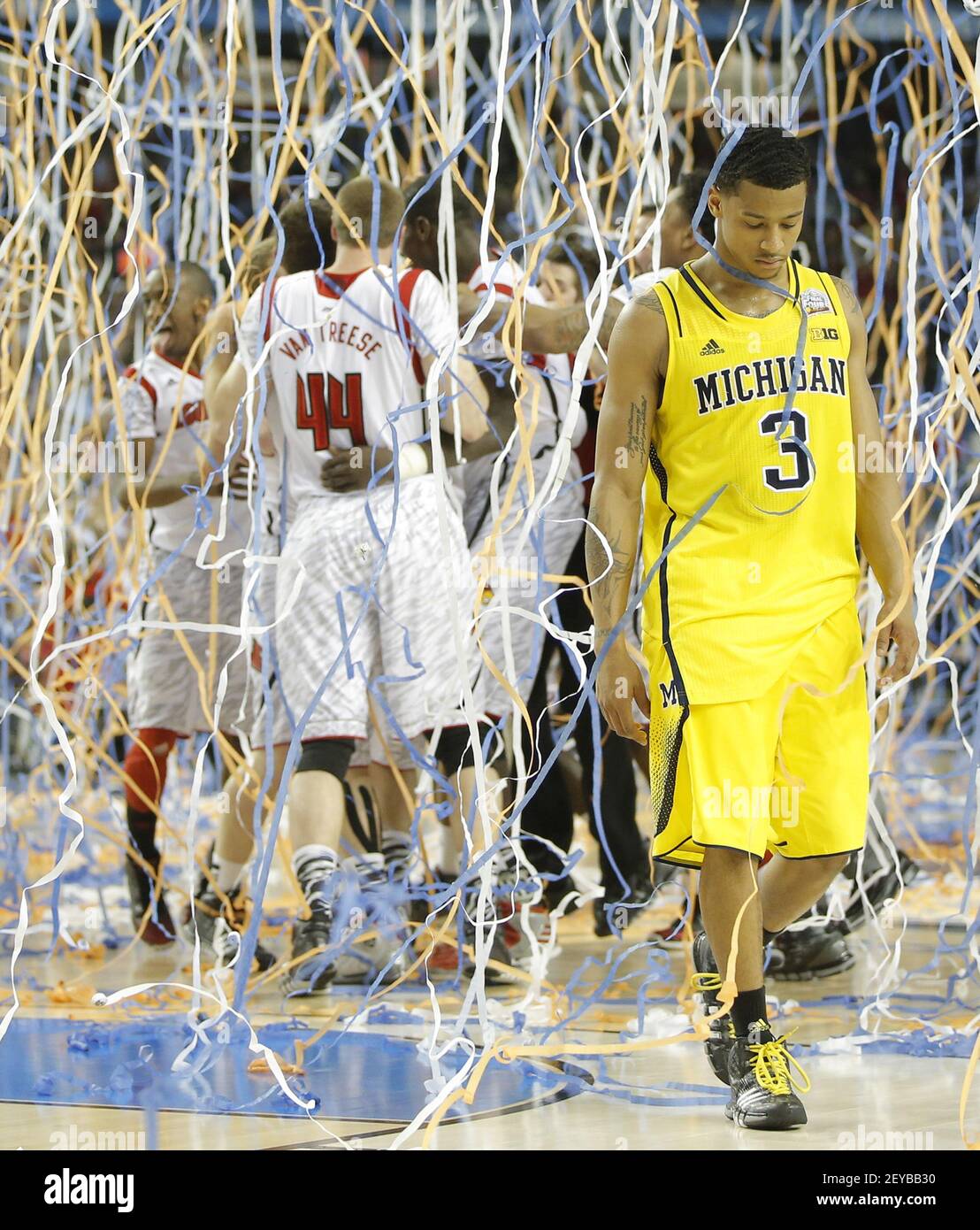 Trey Burke (3) von den Michigan Wolverines geht vom Platz, während Spieler aus Louisville einen 82-76-Sieg in der NCAA Männer Basketball Championship im Georgia Dome in Atlanta, Georgia, am Montag, 8. April 2013 feiern. (Foto von Travis Heying/Wichita Eagle/MCT/Sipa USA) Stockfoto
