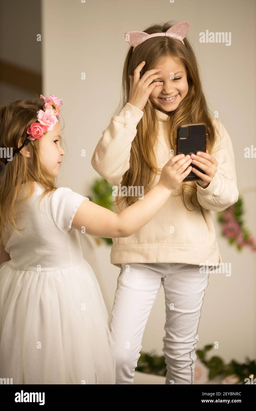 Zwei kleine Mädchen mit Handys. Freundschaft Konzept glücklich kleine Mädchen unter Selfies mit Smartphone Stockfoto