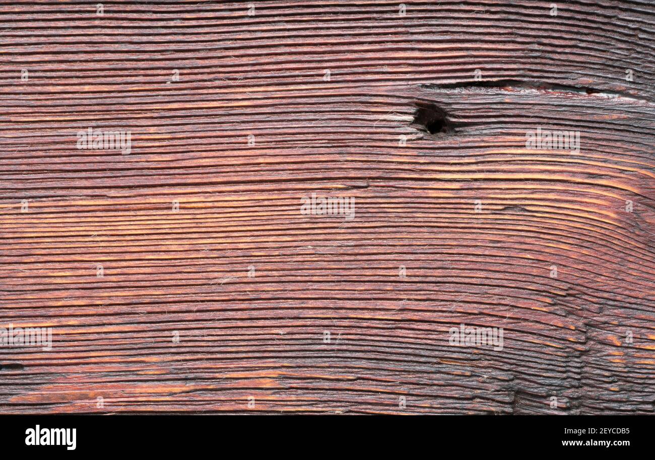 Die alte braune Holzstruktur mit Loch aus Nagel. Makroaufnahme. Naturfaser-Muster aus nächster Nähe Stockfoto