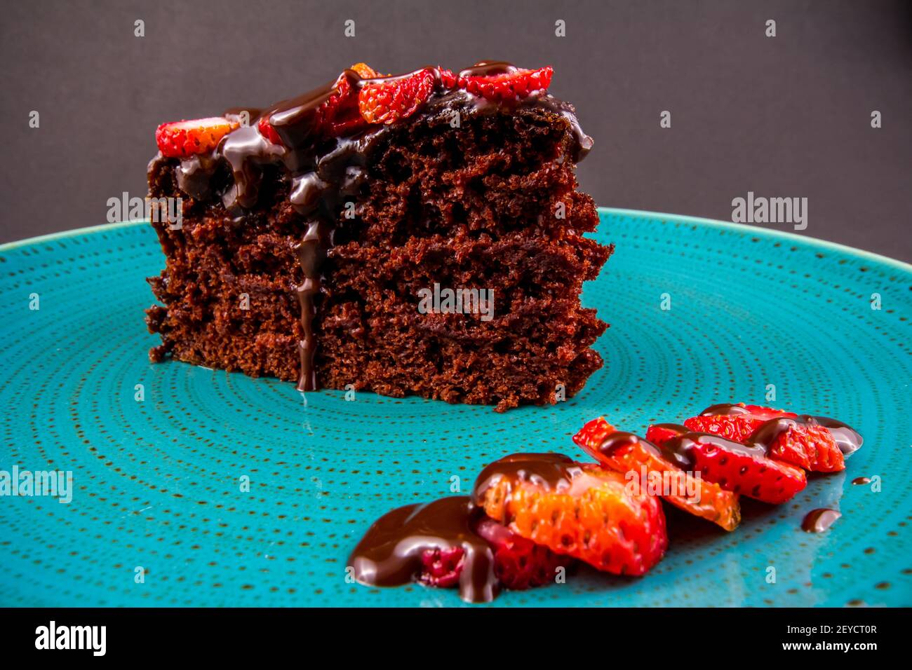 Schokoladenkuchen mit Erdbeeren in türkisfarbener Schale, Nahaufnahme Stockfoto