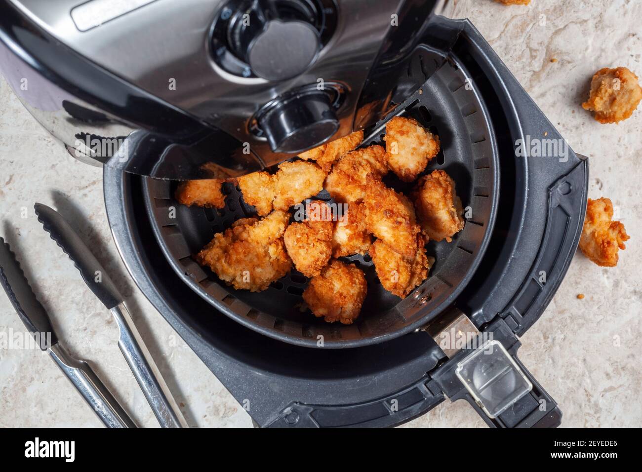 Nahaufnahme eines flachen Lay-Bildes eines Fritteusen-Backofens auf der Arbeitsplatte der Küche. Diese bietet schnelle und einfache knusprige Lebensmittel mit wenig oder gar kein Fett durch Umwälzung heiße Luft Stockfoto