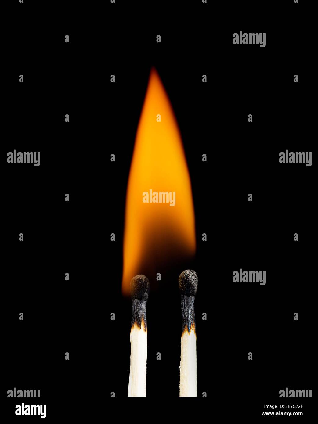 Nahaufnahme von zwei brennenden Streichhölzchen vor schwarzem Hintergrund. Stockfoto