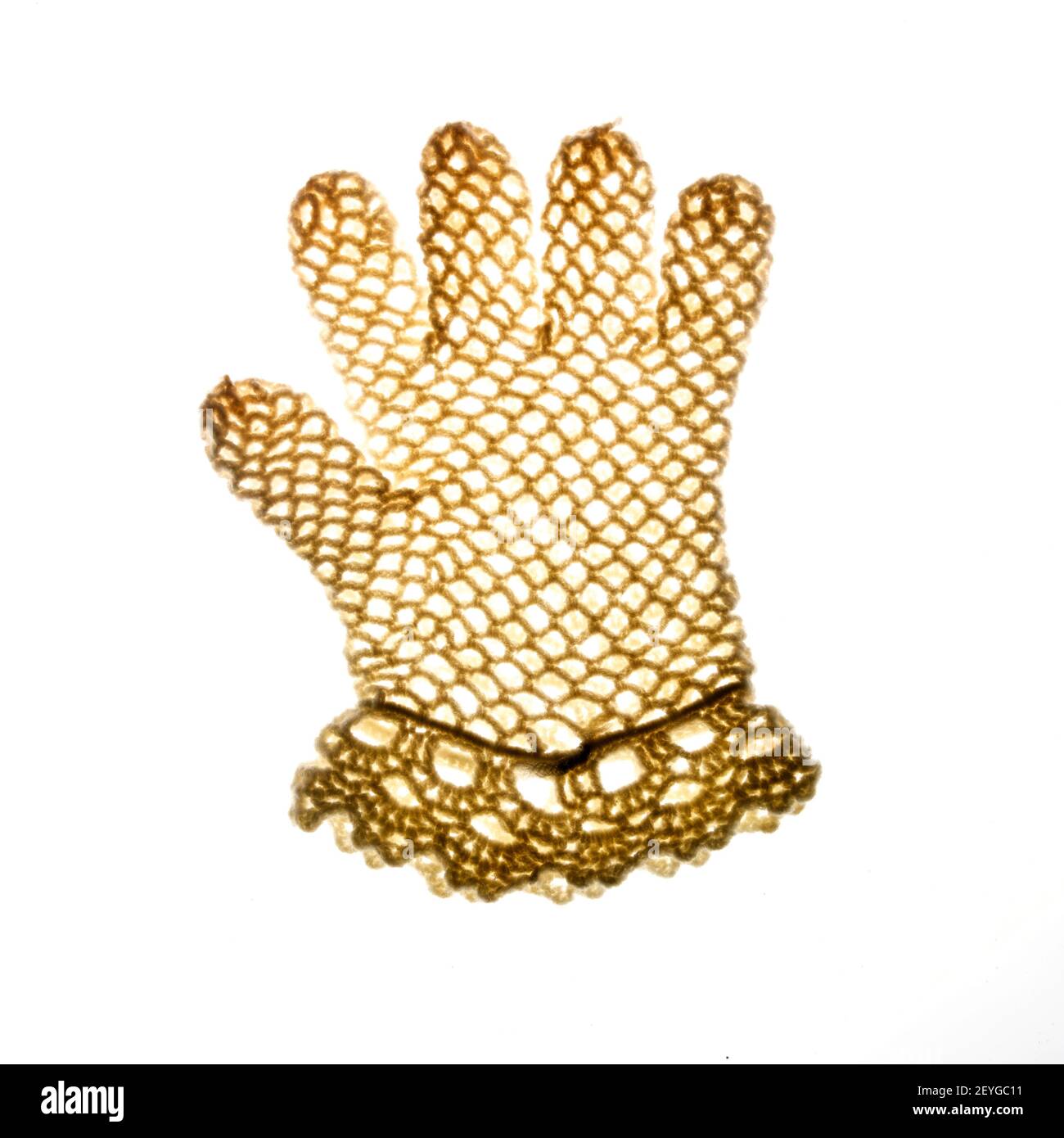 Eine detaillierte Ansicht eines zarten goldenen Spitzenhandschuhs mit komplizierten Mustern und Design auf einem schlichten Hintergrund Stockfoto