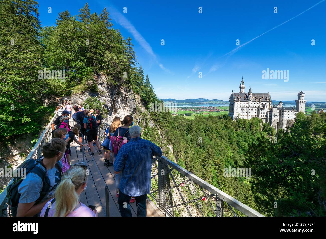 Touristen an der Marienbrücke, einer Fußgängerbrücke, die einen atemberaubenden Blick auf Schloss Neuschwanstein ermöglicht, bei Füssen, Bayern, Deutschland Stockfoto