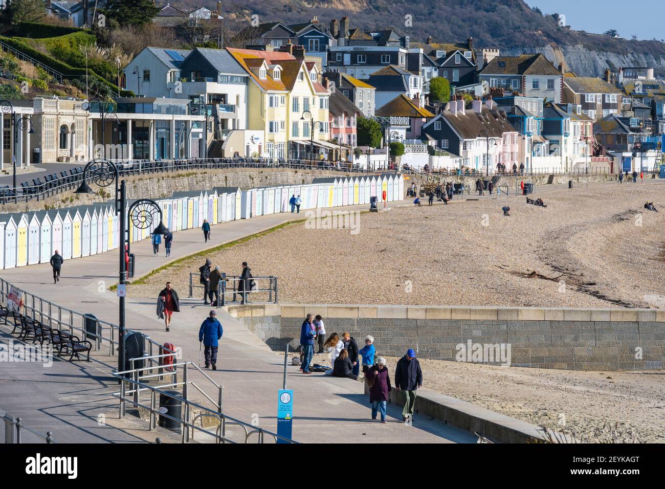 Lyme Regis, Dorset, Großbritannien. März 2021, 6th. UK Wetter: Die Menschen genießen einen kühlen Spaziergang entlang der Küste bei Lyme Regis an einem Morgen von knackigen, hellen Sonnenschein und klaren blauen Himmel. Kredit: Celia McMahon/Alamy Live Nachrichten Stockfoto