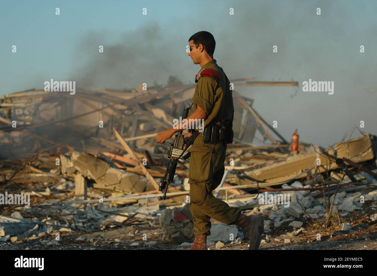 Ein israelischer Soldat geht am 06. September 2005 in der ehemaligen jüdischen Siedlung Neve Dekalim im Gazastreifen an Schutt und abgerissenen Häusern vorbei. Nach fast 40 Jahren Besatzung vollendete Israel die Evakuierung aller 8.000 jüdischen Siedler aus Gaza und mehrerer hundert weiterer aus vier Enklaven im nördlichen Westjordanland. Stockfoto