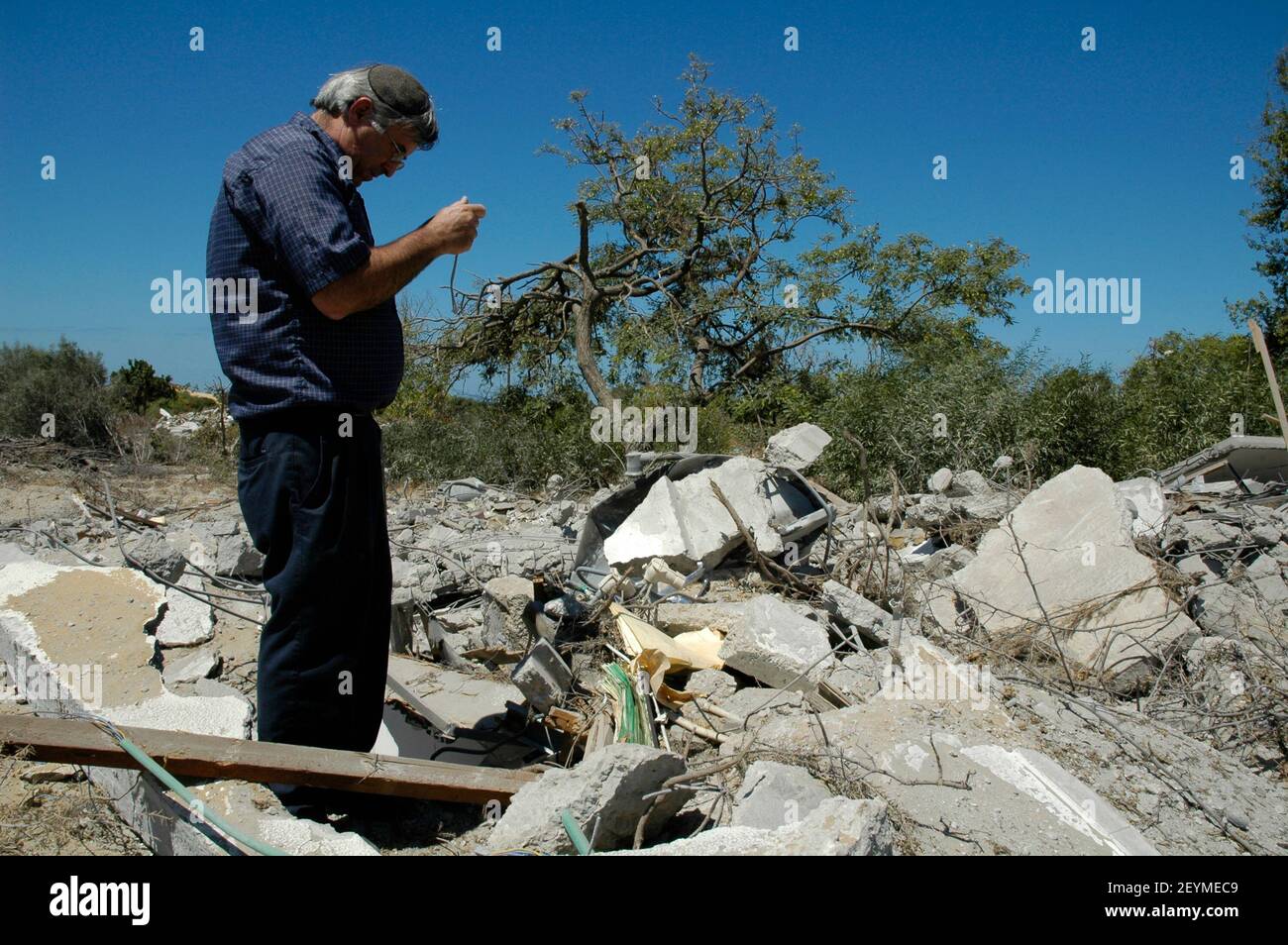 Ein Israeli fotografiert am 06. September 2005 Trümmer von zerstörten Häusern in der ehemaligen jüdischen Siedlung Neve Dekalim im Gazastreifen. Israel beendete die Evakuierung aller 8.000 jüdischen Siedler aus Gaza und mehrere hundert weitere aus vier Enklaven im nördlichen Westjordanland, nach fast 40 Jahren Besatzung. Stockfoto