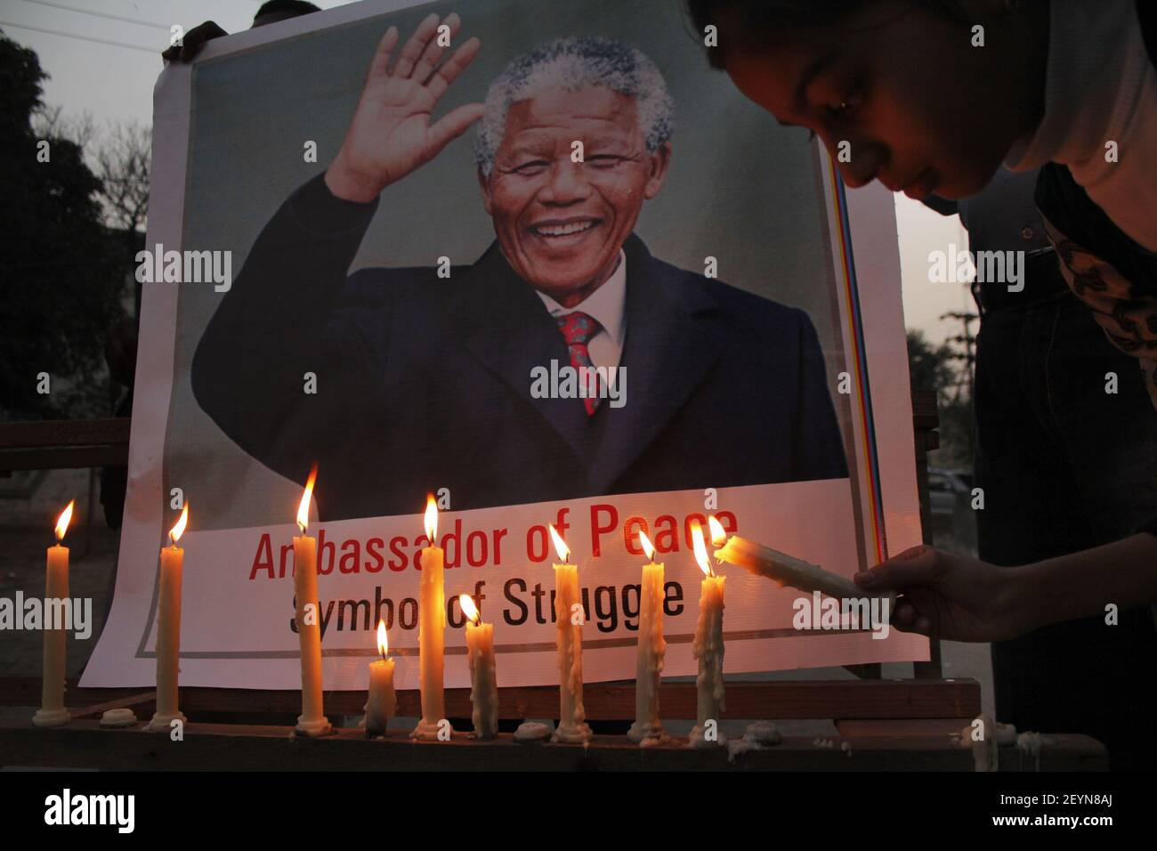 Pakistan zündet Kerzen vor dem Porträt des verstorbenen südafrikanischen Präsidenten Nelson Mandela an, als sie sich zu einem Denkmal in Lahore Pakistan versammeln, Dezember 10,2013. Pakistan, Friedensnobelpreisträger Nelson Mandela starb am 05. Dezember 2013 im Alter von 95 Jahren. (Foto: Rana Sajid Hussain/Sipa USA) Stockfoto