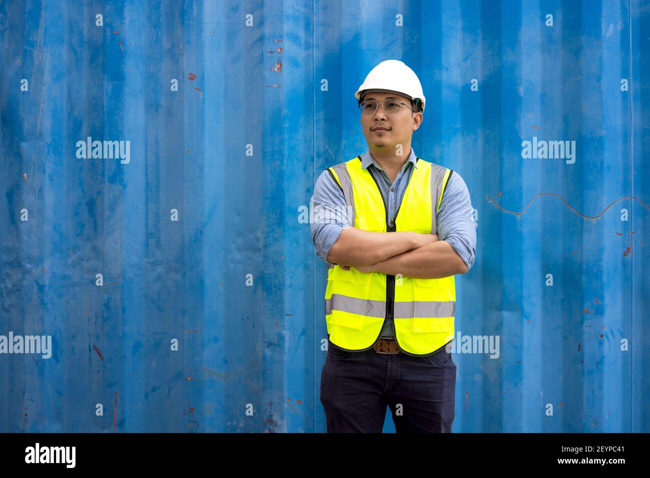 Portrait eines Technikers mit uniformem Schutzanzug und Helm in Industriecontainern. Stockfoto