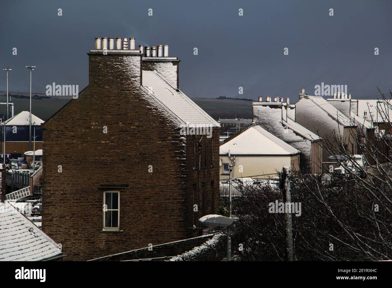 Traditionelle Gebäude Dächer mit Schnee und dunkelblauen Himmel bedeckt Im Hintergrund am Wintertag auf der schottischen Insel im Norden Schottland Stockfoto