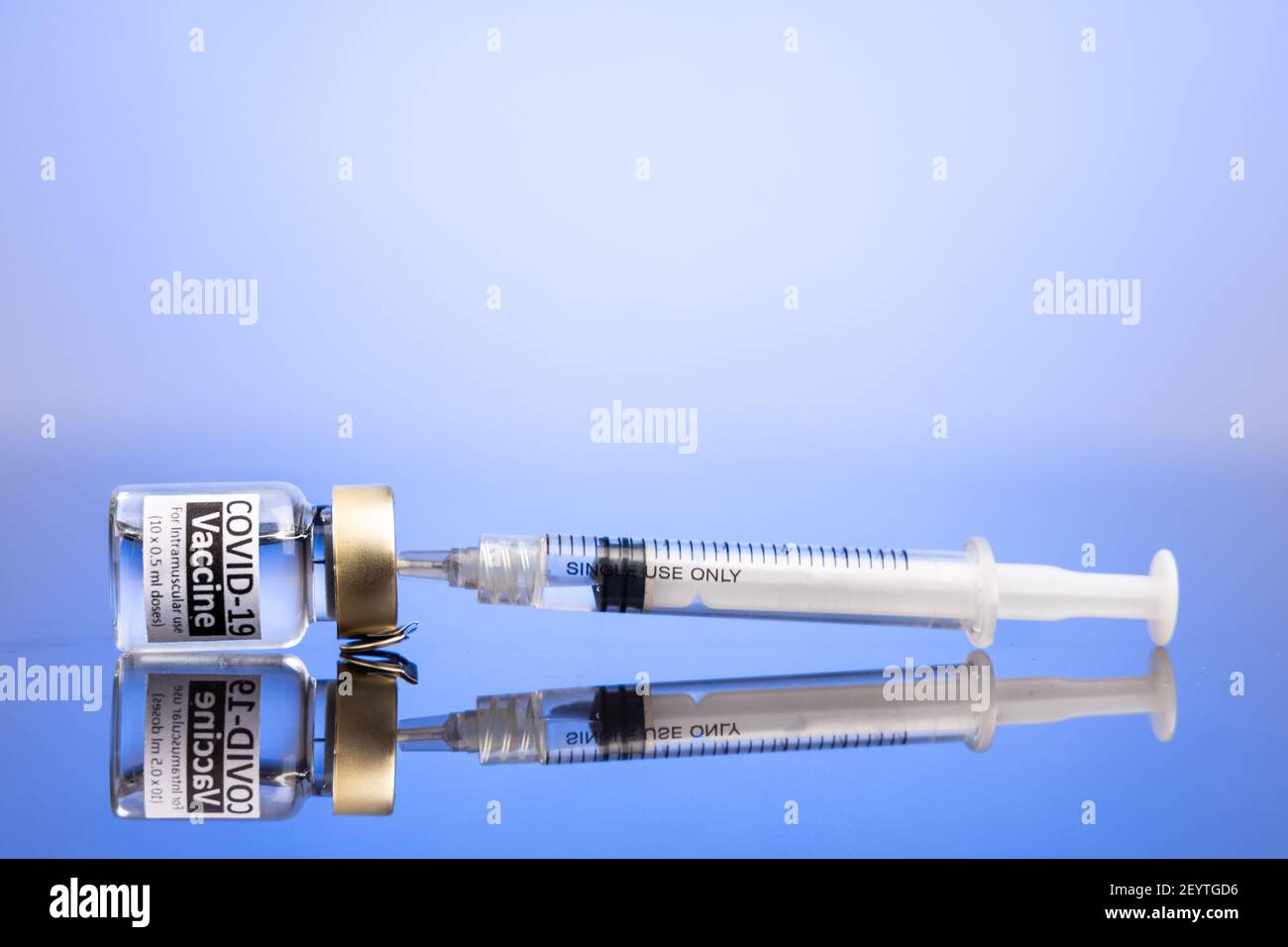 Spritze in Fläschchen mit Covid-19-Impfstoff-Konzept auf blau eingeführt Hintergrund Stockfoto