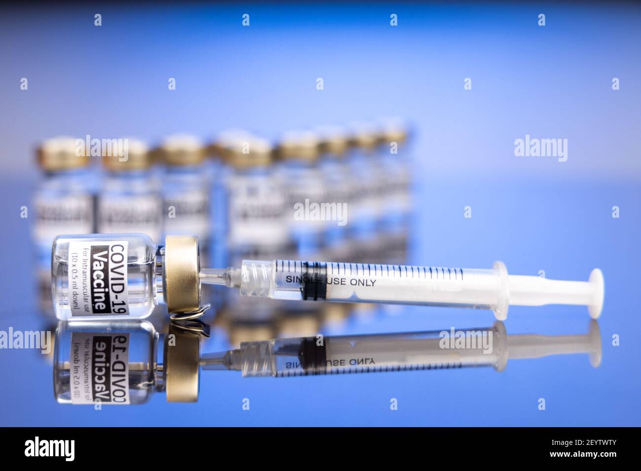 Spritze in Fläschchen mit Covid-19-Impfstoff-Konzept auf blau eingeführt Hintergrund Stockfoto