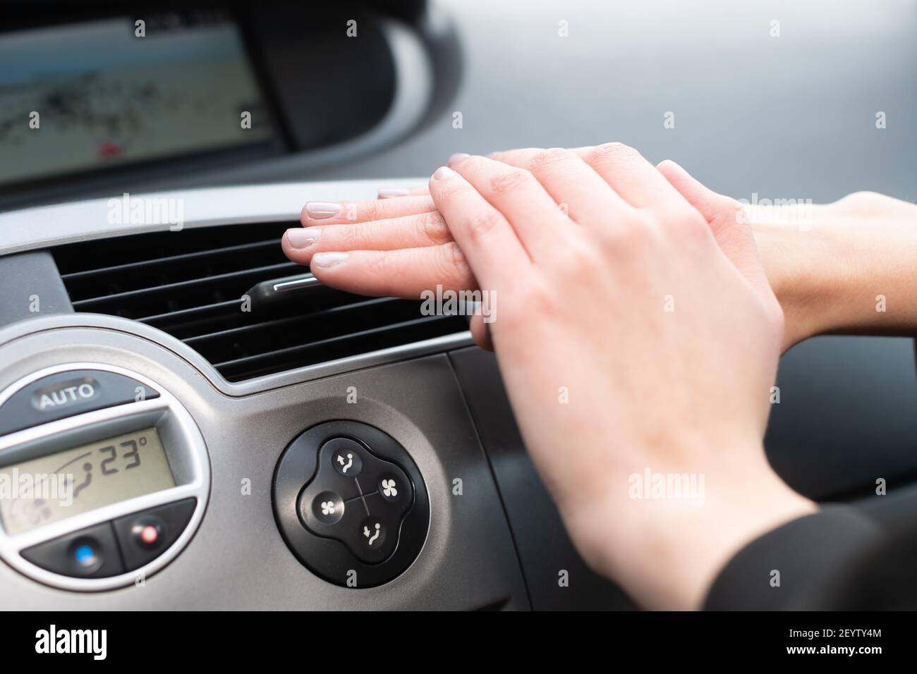 Das Mädchen hält ihre Hände kalt über eine Autoheizung. Heiße Luft  Stockfotografie - Alamy