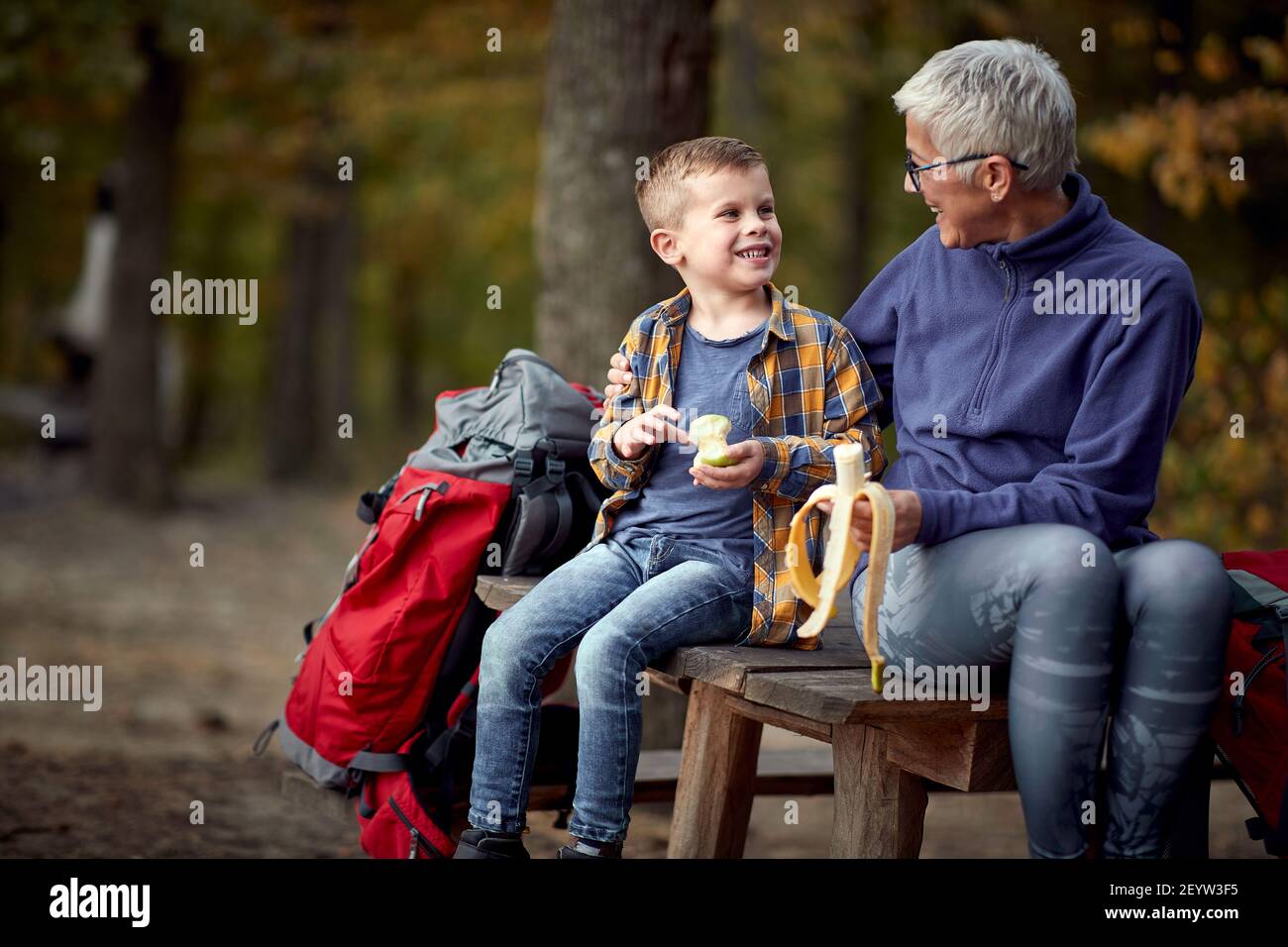 Glückliche Großmutter mit Enkel in der Natur essen Früchte Stockfoto
