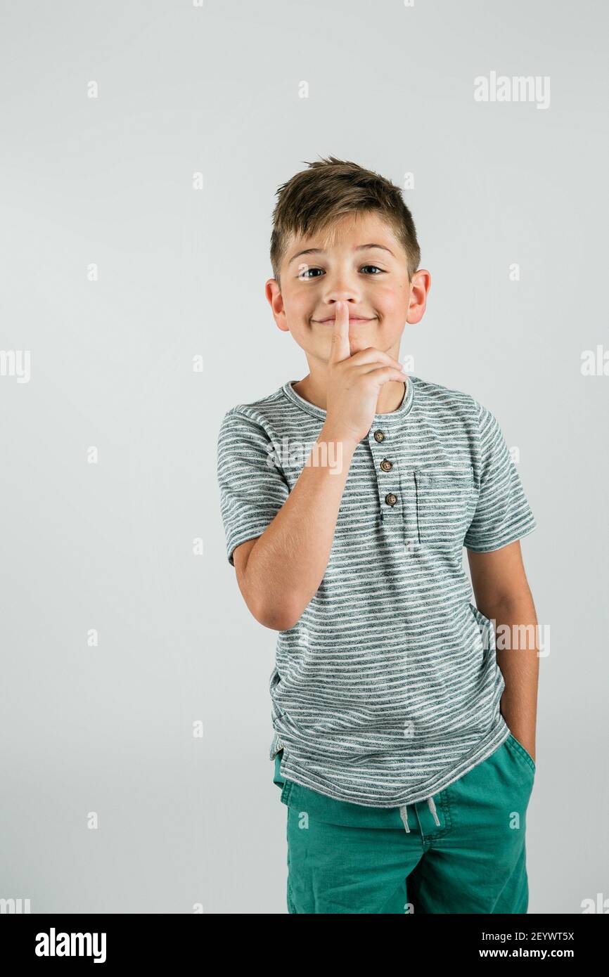 Kleiner Junge mit erhobenem Finger, um nach einer ruhigen Gegend zu schushen. Stockfoto