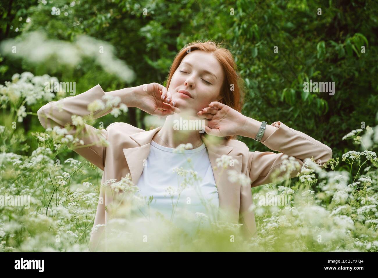 Welt psychische Gesundheit Tag, Work-Life-Balance, verbreiten positive Botschaften Konzept. Rotschopf Frau in Business-Anzug genießen Natur Stockfoto