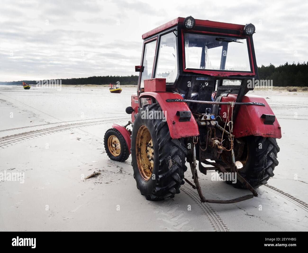 Eine schöne Aussicht auf einen roten Traktor auf einem sandigen Strand Stockfoto