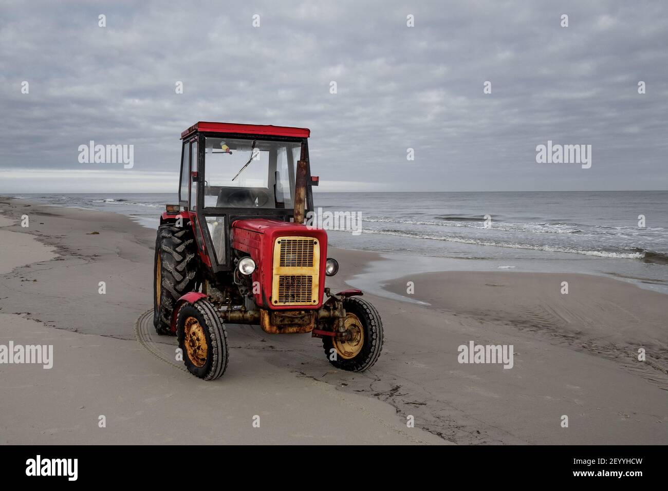 Eine schöne Aussicht auf einen roten Traktor auf einem sandigen Strand Stockfoto