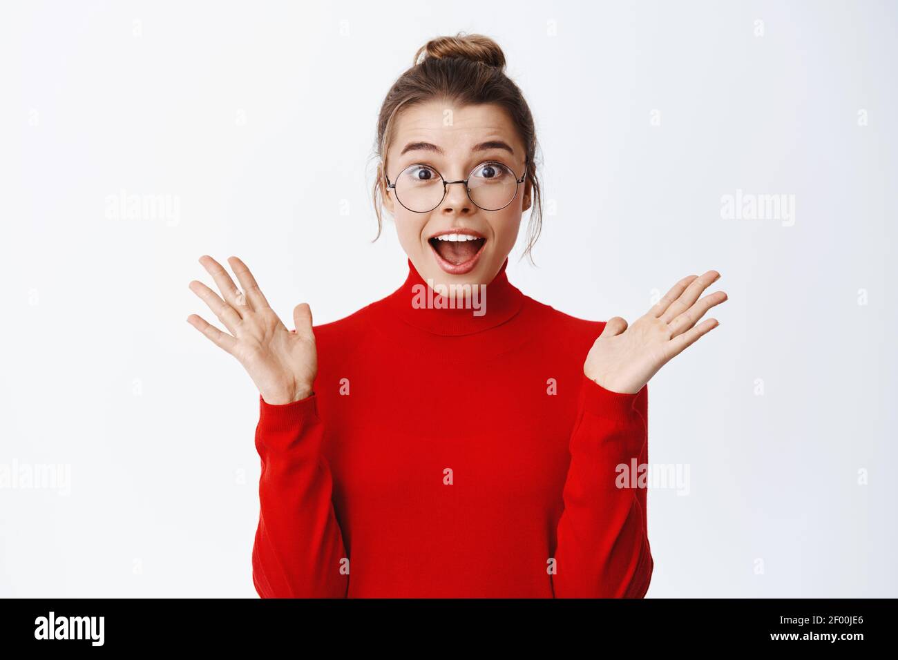 Portrait von aufgeregt schöne Unternehmerin in Gläsern die Hände hoch und keuchen erstaunt, hören gute Nachrichten und suchen erstaunt, stehend in rot Stockfoto
