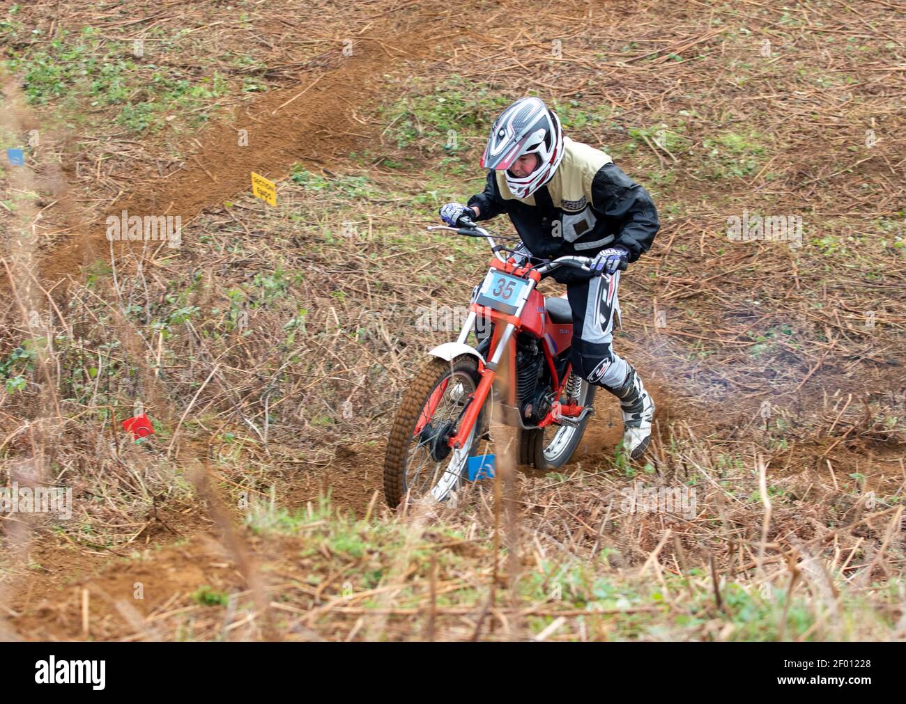 Trials Motorradfahrer Tackling bergauf Abschnitt auf sandigen Coastal Suffolk Erde Stockfoto