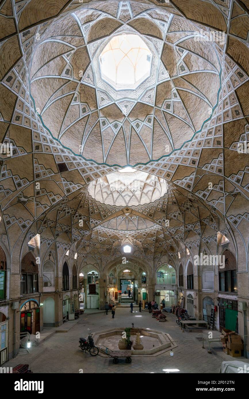 Qom, Iran - 20,04.2019: Geräumige Kuppel des Basar Kreuzung in der orientalischen Stadt Qom. Reich verzierte Wände und Decken. Bogengänge und Torbögen. Stockfoto