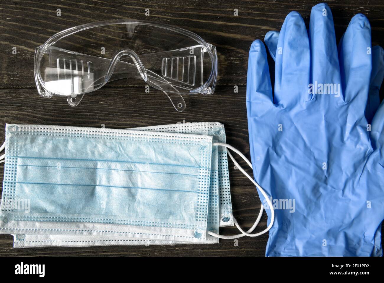COVID-19 Coronavirus Medical Kit, Draufsicht auf OP-Maske, Schutzbrille und Handschuhe. Flache Laienzusammensetzung der persönlichen Ausrüstung (PSA). Konzept Stockfoto