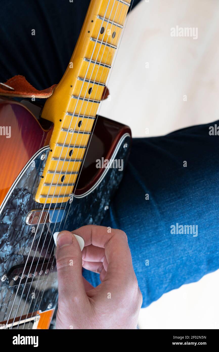 Nahaufnahme Vertikale Ansicht Blick auf einen Mann zu Hause Spielen einer Fender Telecaster Modern Player E-Gitarre mit einem Kunststoffpicker Stockfoto