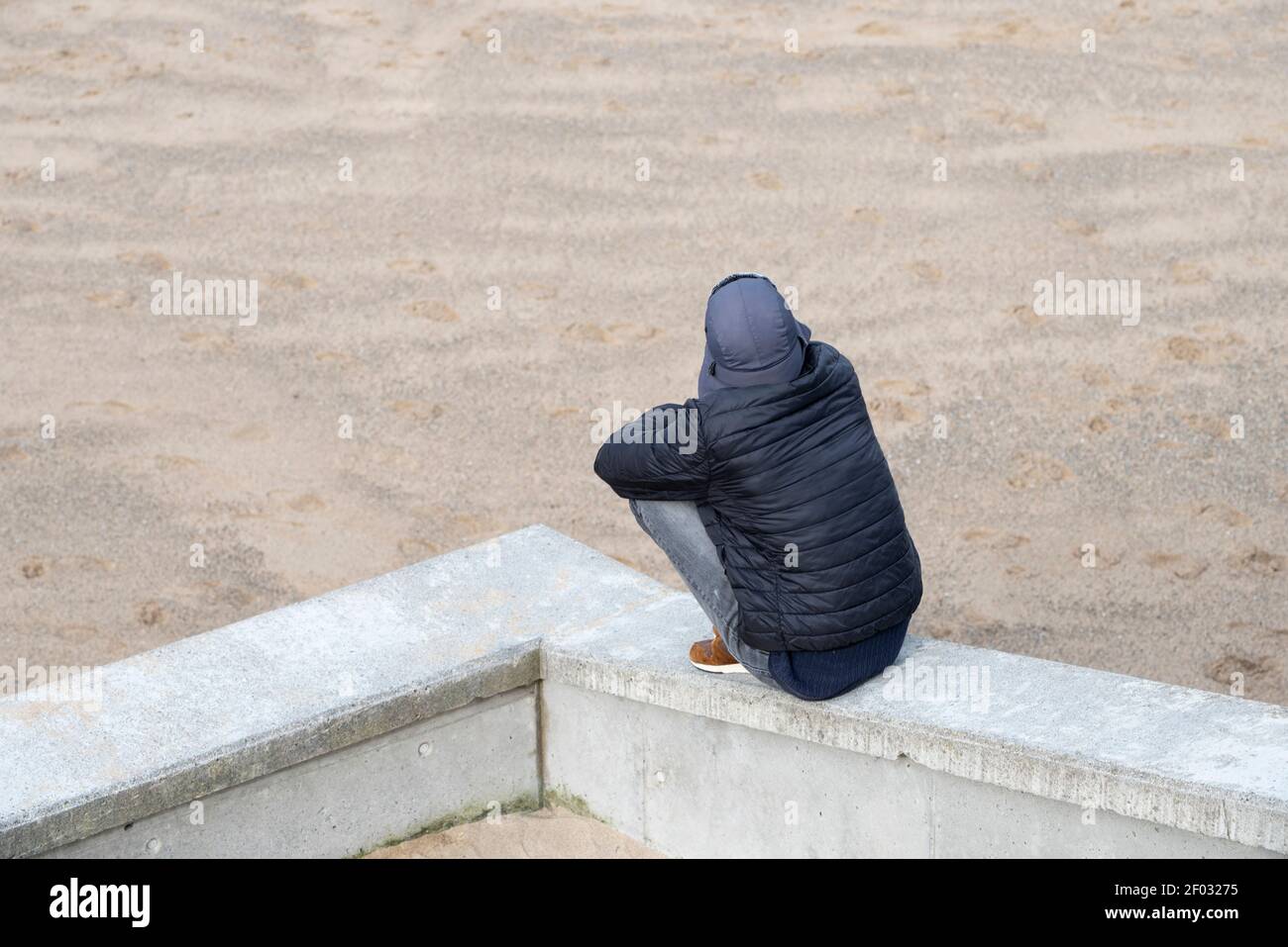 Einsame Person, die am Strand denkt Stockfoto