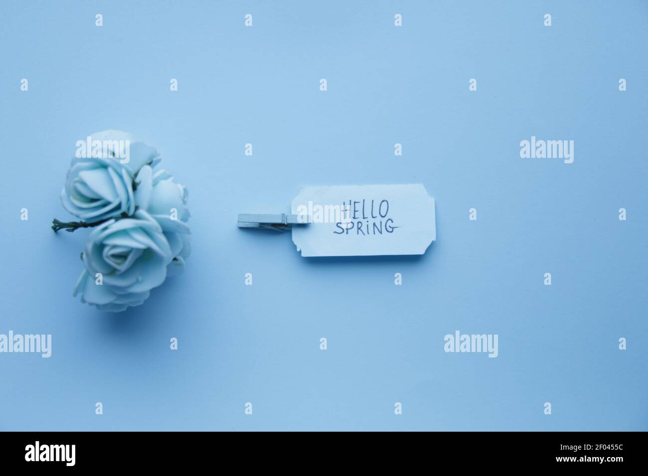 Hallo Frühling. Die Inschrift auf einem blauen Etikett auf einem blauen Hintergrund. Stockfoto