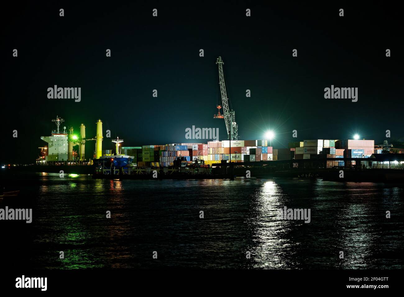 Frachthafen in Stonetown (Tansania, Sansibar Archipel) am Abend und in der Nacht mit Kran und Container. Straßen und Hafen in der alten Steinstadt von Stockfoto