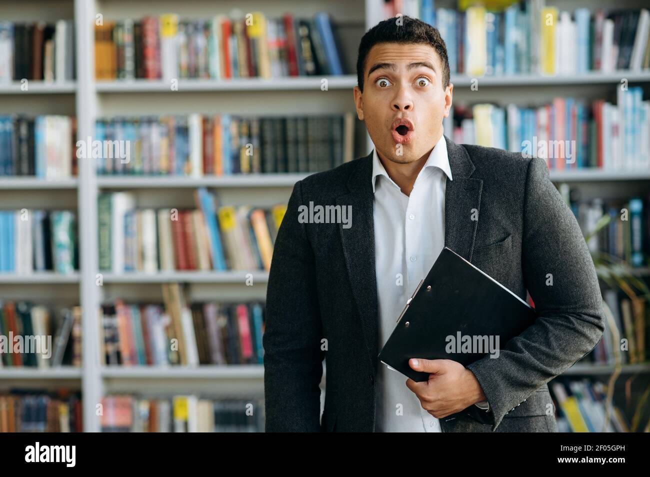 Porträt eines schockierten hispanischen Unternehmers oder Studenten in stilvollem Anzug. Überrascht junge Geschäftsmann Blick auf die Kamera, unerwartete Nachrichten zu hören oder vergessen über wichtige Treffen Stockfoto