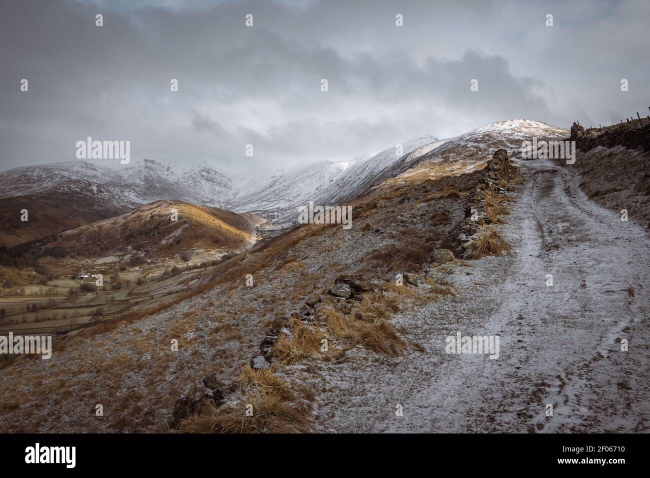 Schnee und Eis bedeckt Garburn Track, wie es aufsteigt Troutbeck Richtung Kentmere mit Troutbeck Zunge und der kranken Glocke Grat in der Ferne Stockfoto