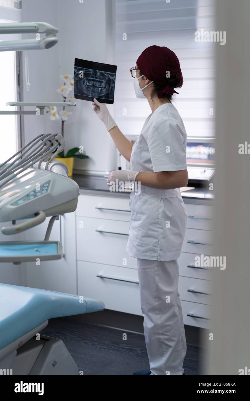 Seitenansicht des wehmütigen Arztes in einheitlichem Untersuchungsbild der Radiographie Des Patienten beim Nachdenken über die Diagnose Stockfoto