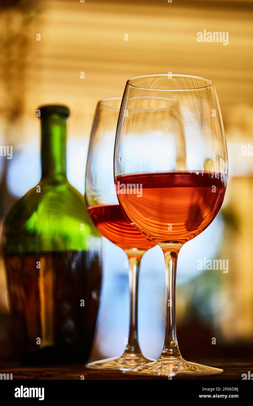 Zwei Gläser gefüllt mit Rotwein und Flasche im Hintergrund Stockfoto