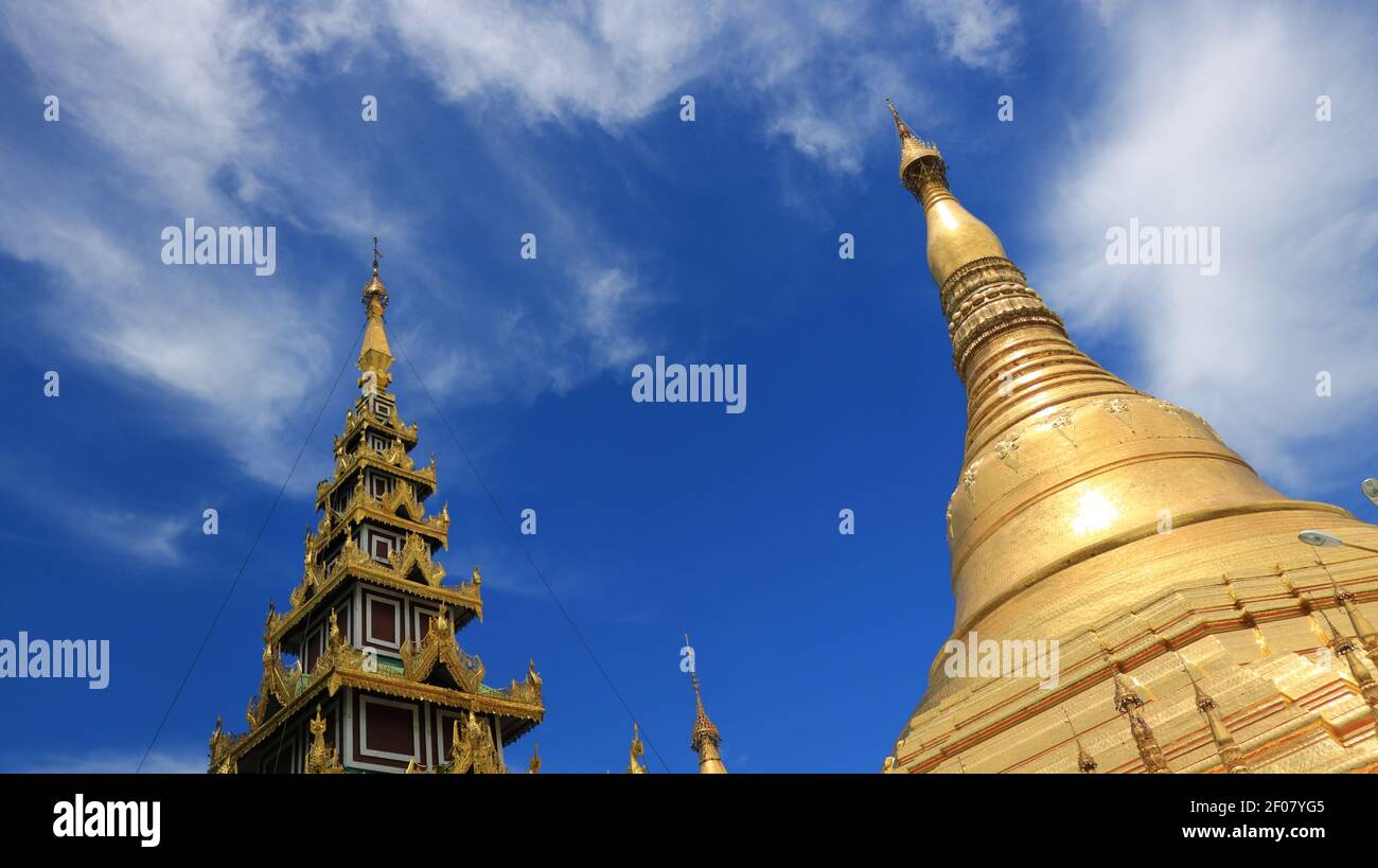 Zwei goldene Tempel mit wolkenblauem Himmel innerhalb der Shwedagon Pagode Komplex in Yangoon Myanmar (Birma) Stockfoto