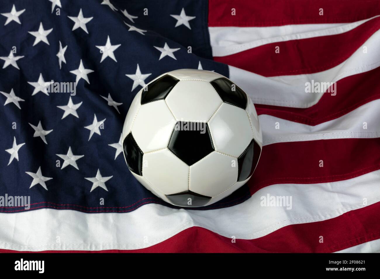 Traditioneller Lederfußball mit amerikanischer Flagge im Hintergrund Stockfoto
