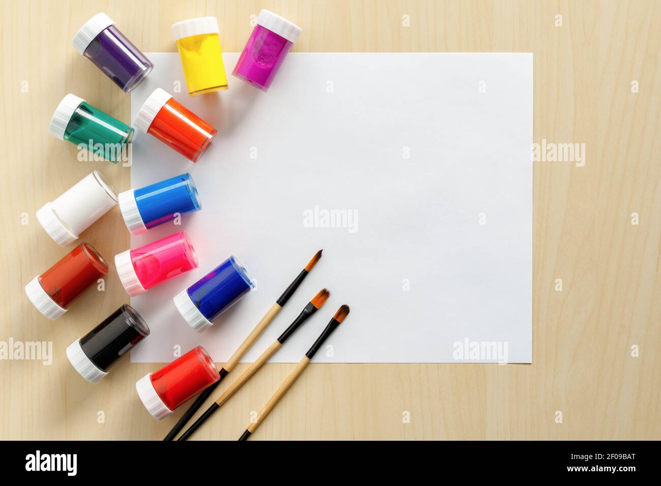 Künstler und Malmockup mit weißem Papier auf Holzgrund, Pinsel, Farbe und Aquarell. Stockfoto