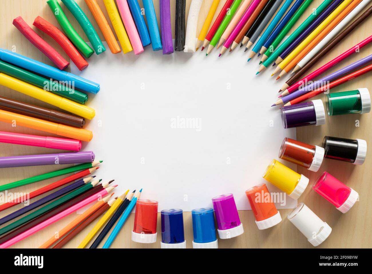 Eine Gruppe von hellen Kunstgegenständen auf dem Schreibtisch mit leerem weißen Papier und Kopierraum in der Mitte. Stockfoto