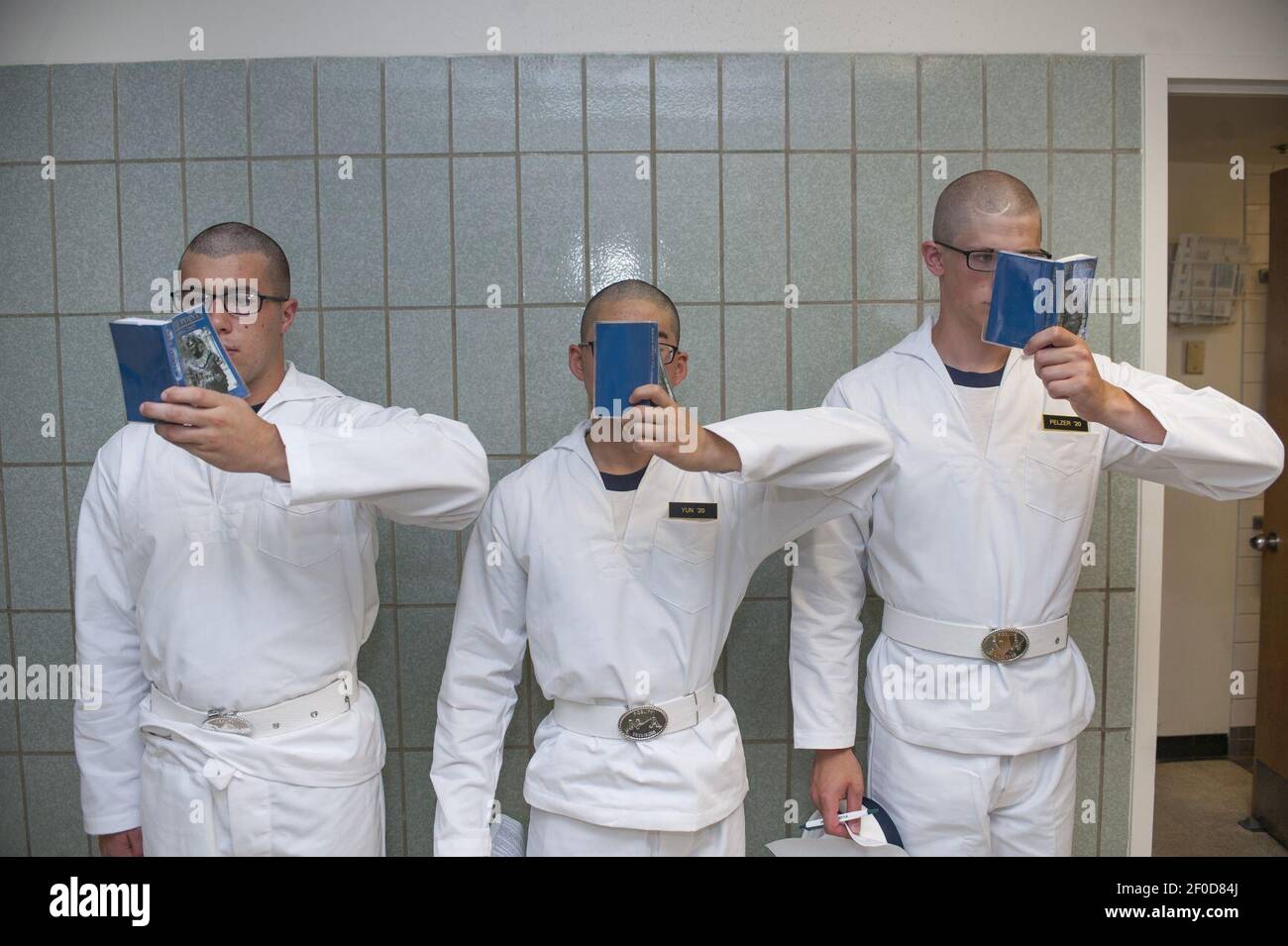 Plebes stehen gegen eine Wand in Bancroft Hall und lesen ihr Buch "Reef Points" während des Einführungstages (I-Day) 2016. (27405303604). Stockfoto