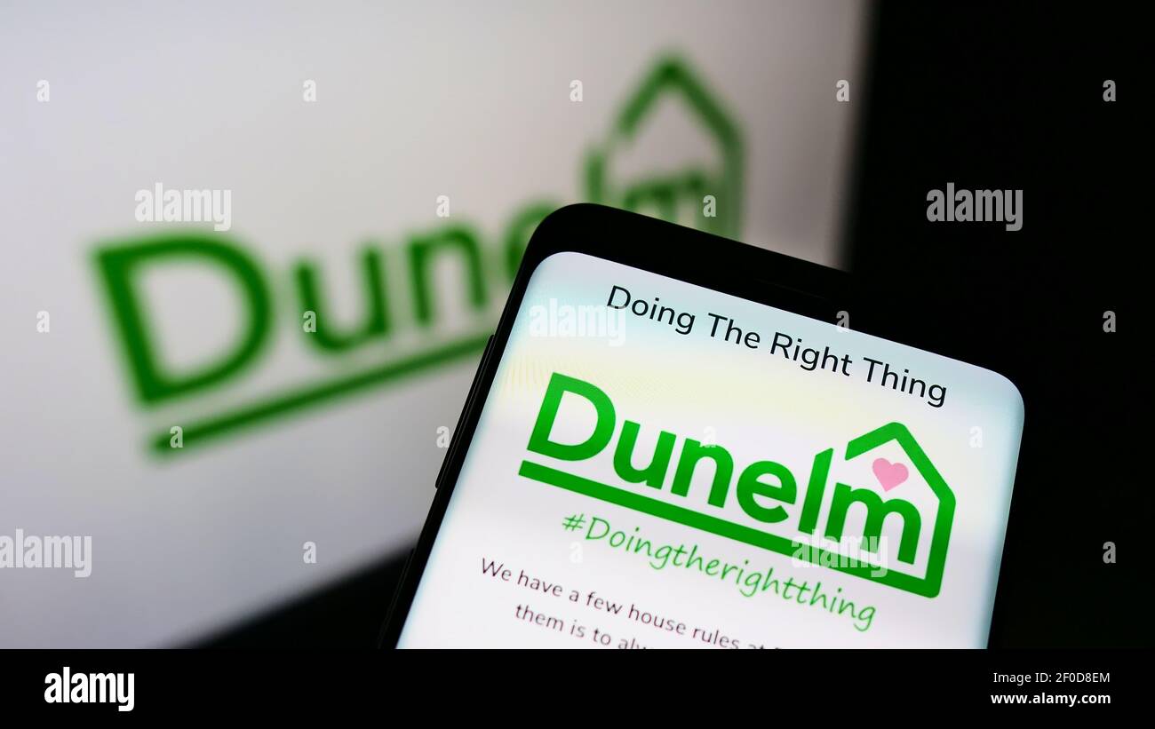 Handy mit Unternehmens-Website des britischen Einzelhändlers Dunelm (Soft Furnishings) Ltd auf der oberen Mitte des Bildschirms vor dem Logo. Konzentrieren Sie sich auf die Telefonanzeige. Stockfoto