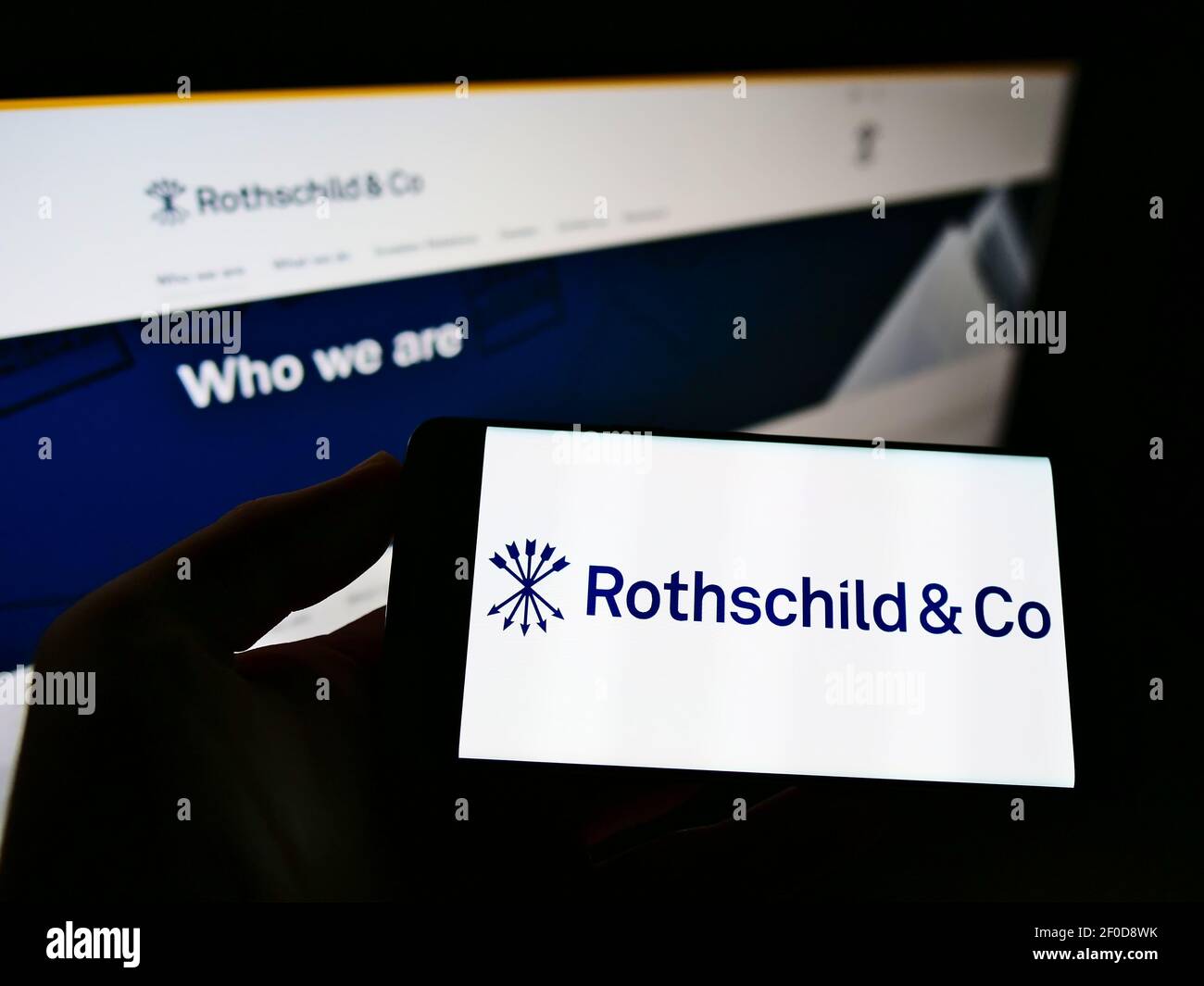 Person, die Smartphone mit Logo des französischen Finanzdienstleisters Rothschild Co. SCA auf dem Bildschirm vor der Website hält. Konzentrieren Sie sich auf die Telefonanzeige. Stockfoto
