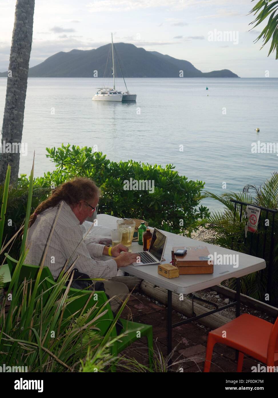 Mann, der auf einem Laptop im tropischen Inselparadies Fitzroy Island, Great Barrier Reef, in der Nähe von Cairns, Queensland, Australien. Nein, MR Stockfoto