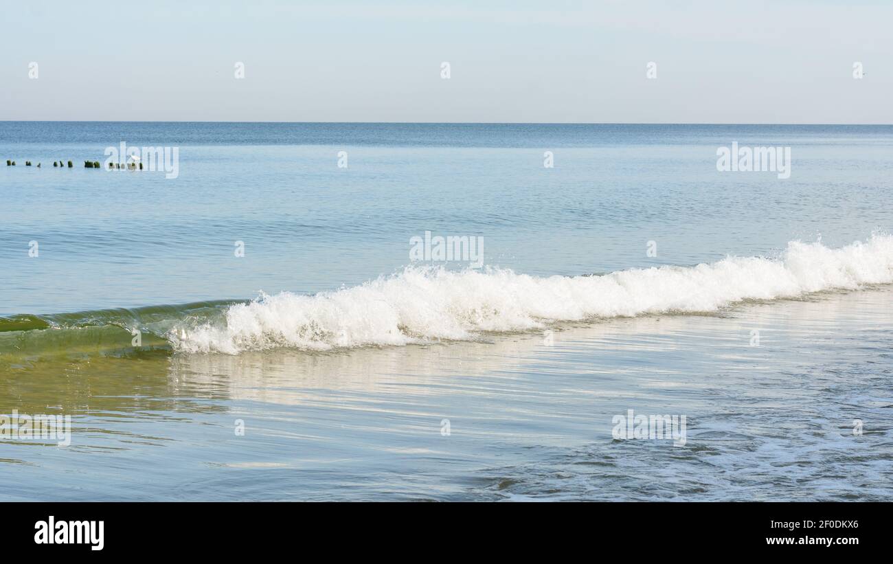 Welle mit weißem Schaum in der Sonne nähert sich Küste. Weitwinkelpanorama. Seascape am Abend, Stimmung der Sommerreise. Stockfoto