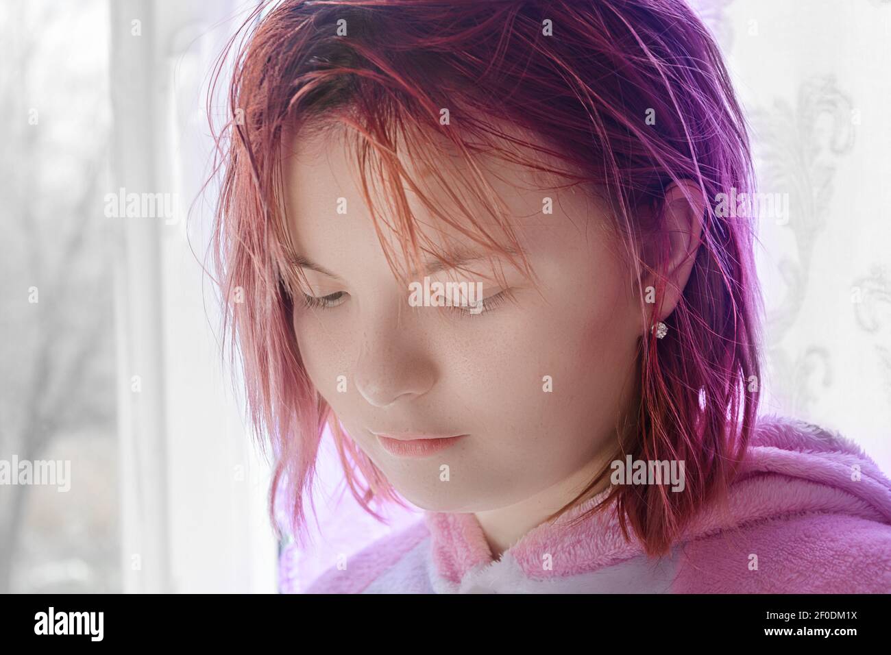 Portrait von Teenager-Mädchen mit roten Haaren. Lady senkt ihre Augen und schaut nach unten. Traurige Emotionen im Gesicht. Nahaufnahme, selektiver Fokus. Stockfoto